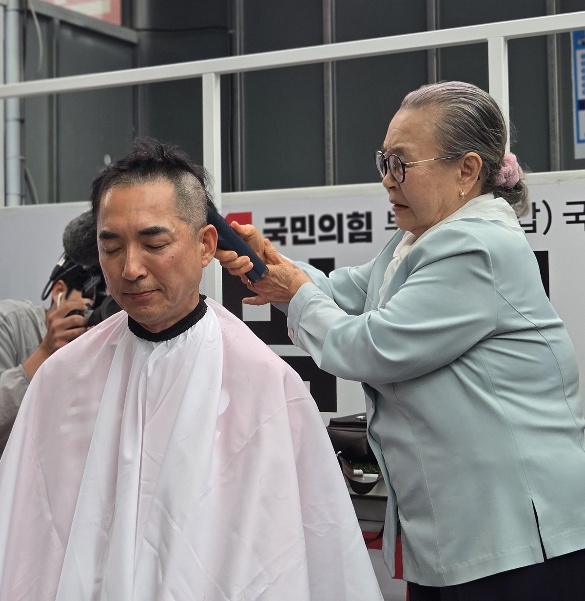 박민식 국민의힘 부산 북구갑 국회의원 보궐선거 후보가 공식 선거운동 첫날인 21일 오후 부산 북구 구포시장 인근 쌈지공원에서 열린 출정식에서 삭발하고 있다. / 뉴스1