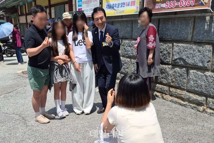 박수현 더불어민주당 충남도지사 후보는 24일 천안 각원사 셔틀버스 대기 줄에 선 시민들과 함께 사진을 찍고 있다. ⓒ데일리안 김주혜 기자