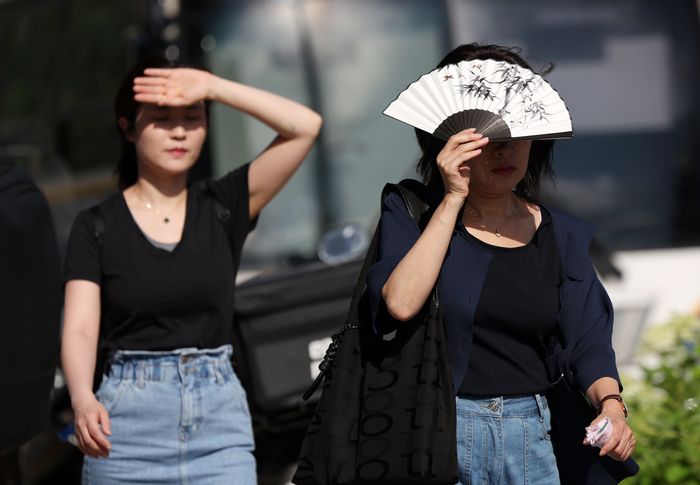 시민들이 뜨거운 햇살을 가리고 있다. ⓒ뉴시스
