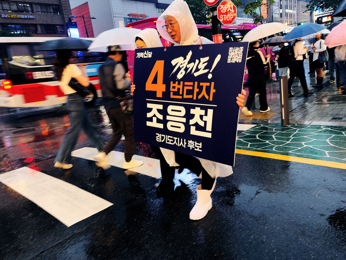 조응천 개혁신당 경기도지사 후보가 20일 저녁 신논현역 광역버스정류장에서 비를 맞으며 거리 유세를 하고 있다. ⓒ조응천 캠프