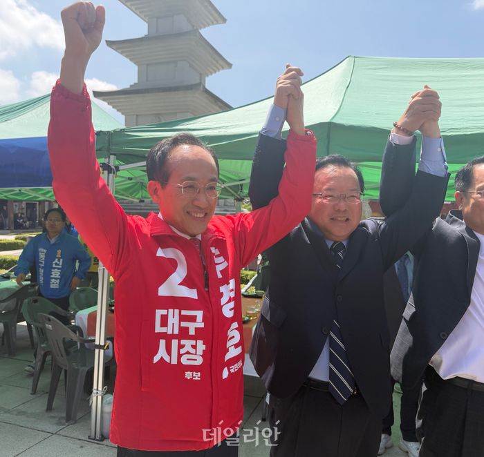 추경호(왼쪽) 국민의힘 대구시장 후보와 김부겸 더불어민주당 대구시장 후보가 24일 오전 대구 동구 팔공산 동화사를 찾아 팔을 들어올리고 있다. ⓒ 데일리안 김수현 기자