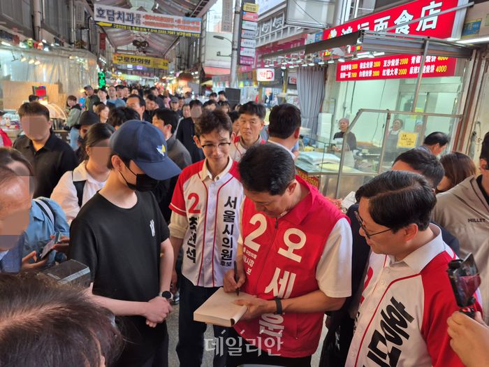 오세훈 국민의히 서울시장 후보가 21일 서울 구로구에 있는 구로시장을 찾자 한 청년이 사인을 요청하고 있다. ⓒ데일리안 김주훈 기자