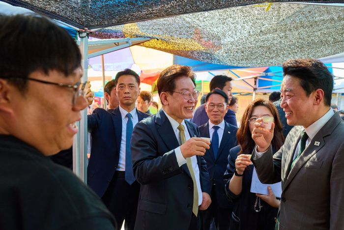 이재명 대통령이 14일 경기 성남 모란시장을 방문해 강훈식 비서실장과 시식을 하며 대화하고 있다. ⓒ뉴시스