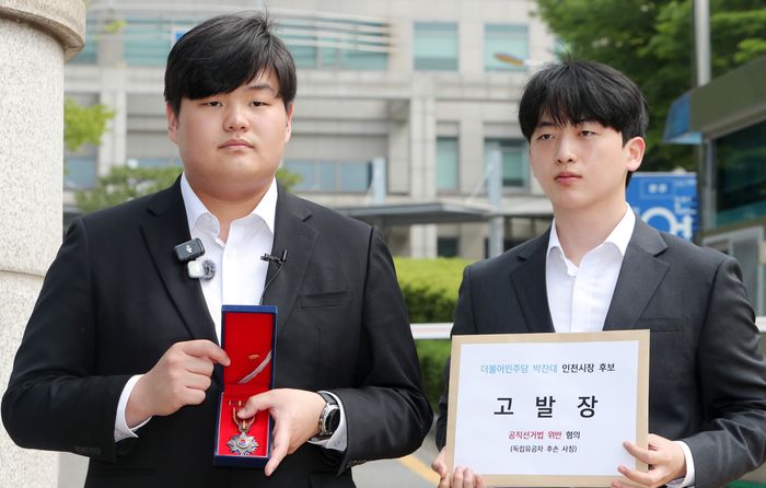 29일 인천경찰청 앞에서 독립유공자 박진해 선생의 직계 5대손 박기현씨가 더불어민주당 박찬대 인천시장 후보 고발장 제출에 앞서 독립유공자 건국훈장을 공개하고 있다.ⓒ 유정복 캠프 제공