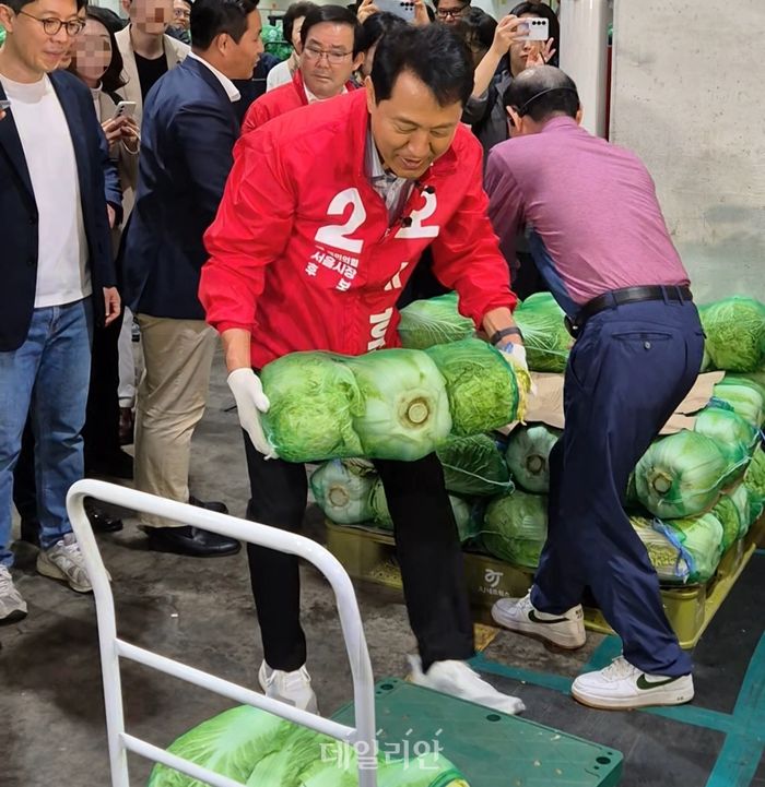 오세훈 국민의힘 서울시장 후보가 21일 새벽 서울 가락동 농수산물도매시장을 찾아 수레에 배추를 옮기고 있다. ⓒ데일리안 김주훈 기자