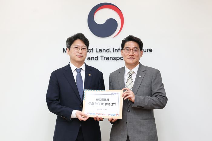 윤성진 화성특례시장 권한대행(오른쪽)이 홍지선 국토교통부 제2차관에게 화성특례시 주요 현안 및 정책 건의서를 전달하고 있다. ⓒ화성시 제공