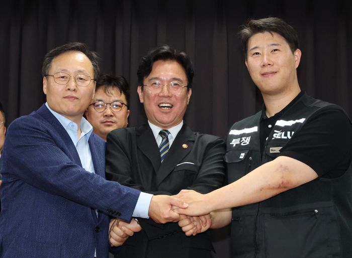 20일 경기 수원시 장안구 경기고용노동청에서 열린 삼성전자 임금협상을 마친 후 여명구 삼성전자 DS(디바이스솔루션·반도체 사업 담당) 피플팀장(왼쪽부터)과 김영훈 고용노동부 장관, 최승호 삼성그룹 초기업노동조합 삼성전자지부 위원장이 잠정 합의한에 서명한 후 손을 맞잡고 파이팅을 외치고 있다. (공동취재) ⓒ뉴시스
