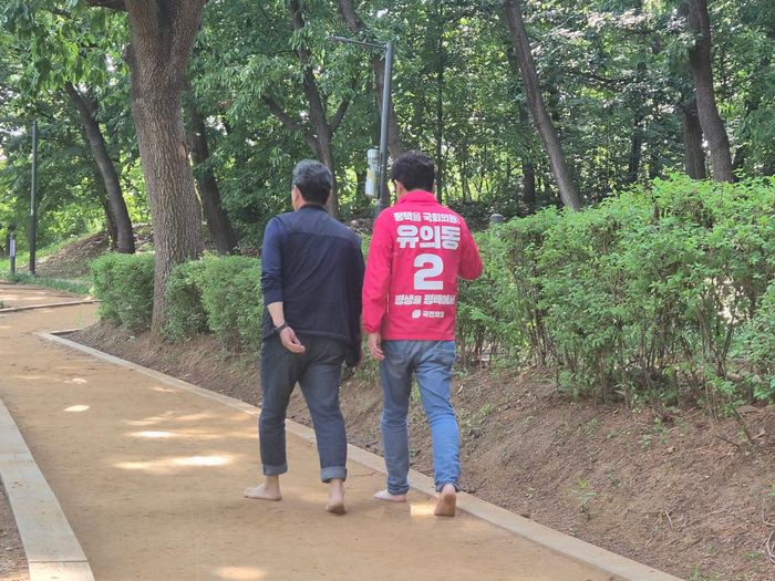 유의동 국민의힘 후보가 23일 오후 경기 평택시 고덕동에 위치한 함박산 중앙공원 맨발 산책길에서 한 시민과 맨발로 산책하며 이야기를 나누고 있다. ⓒ데일리안 허찬영 기자