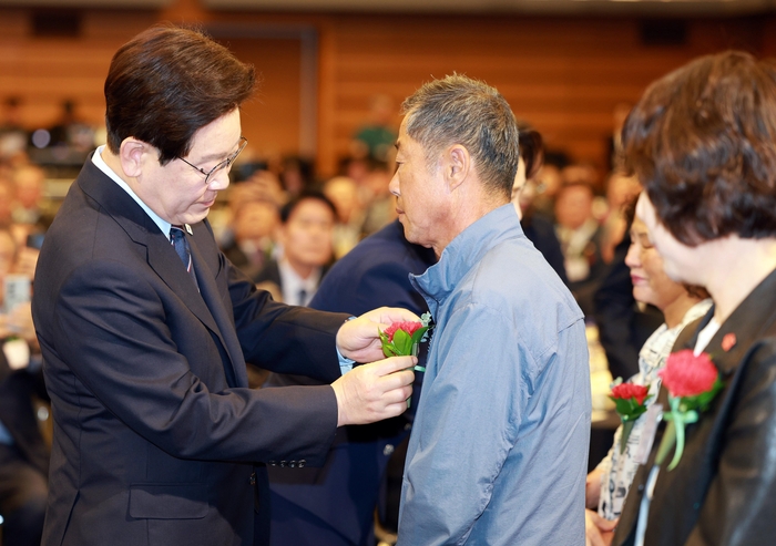 이재명 대통령이 8일 서울 중구 대한상공회의소에서 열린 어버이날 기념식에서 순직 소방관, 경찰관 부모님들에게 카네이션을 달아드리고 있다. 연합뉴스