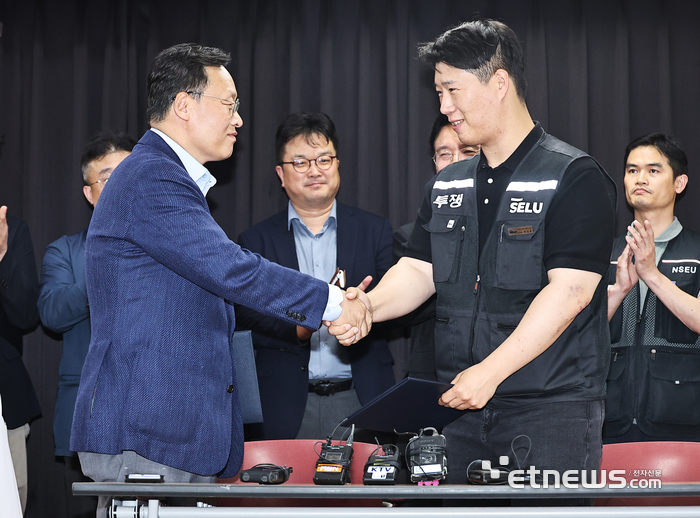 20일 경기도 수원시 장안구 경기고용노동청에서 열린 삼성전자 임금협상을 마친 후 여명구 삼성전자 디바이스솔루션(DS·반도체 사업 담당) 부문 피플팀장과 최승호 삼성그룹 초기업노동조합 삼성전자지부 위원장이 잠정 합의안에 서명한 후 악수하고 있다.  연합뉴스