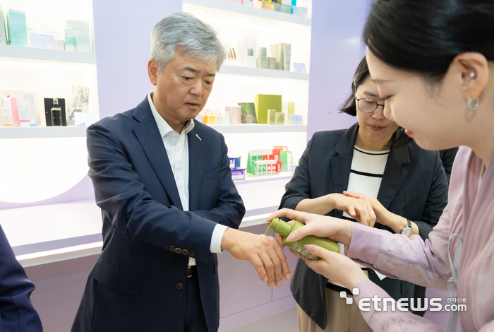 28일 서울 강남구 삼성동 코엑스에서 한국무역협회 이인호 부회장이 K-소비재 홍보·체험관인 '아우라'에 전시된 화장품을 체험해보고 있다. 무협 제공