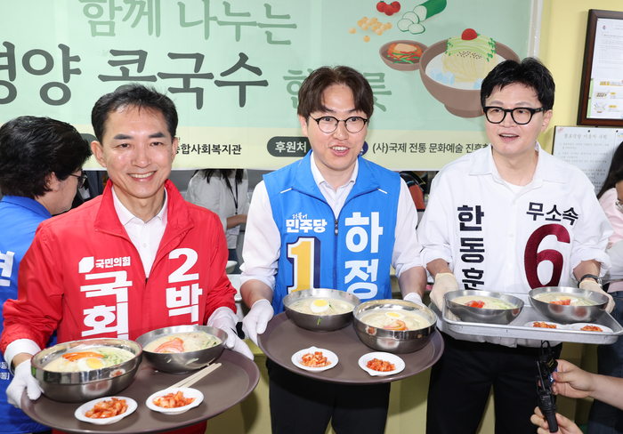 국민의힘 박민식(왼쪽부터), 더불어민주당 하정우, 무소속 한동훈 부산 북구갑 국회의원 보궐선거 후보가 21일 부산 북구 남산정종합사회복지관에서 열린 콩국수 나눔 행사에 참석해 콩국수 배식 봉사를 하고 있다. 연합뉴스