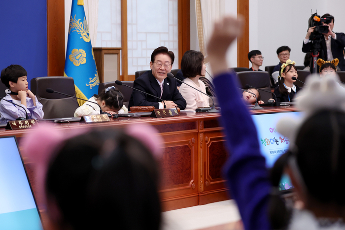 이재명 대통령과 김혜경 여사가 5일 청와대에서 열린 어린이날 초청행사 참석자들과 함께 국무회의 체험을 하고 있다. 연합뉴스