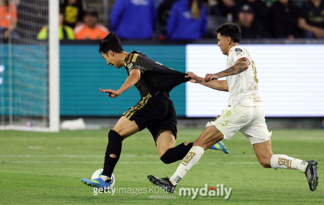 LAFC의 손흥민(왼쪽)이 2026년 4월 미국 LA에서 열린 톨루카와의 2026시즌 북중미축구연맹 챔피언스컵 4강 1차전에서 드리블을 하고 있는 상황에서 톨루카의 카스트로가 유니폼을 잡아 당기고 있다./게티이미지코리아