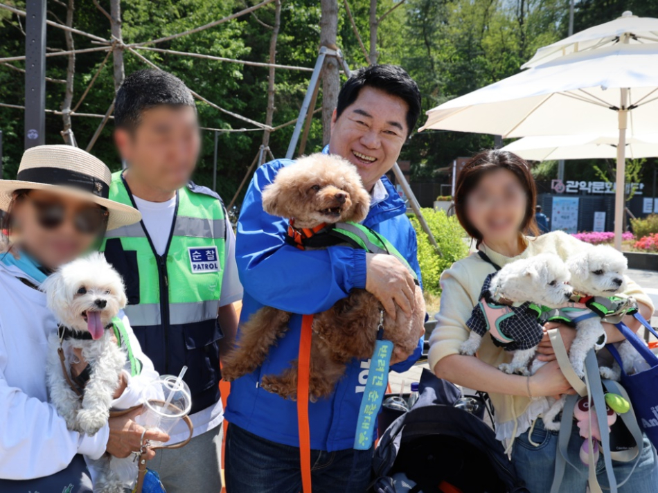 박준희 더불어민주당 관악구청장 후보가 지난 2일 서울 관악구 곽안산 으뜸공원에서 열린 ‘찾아가는 동물병원’ 행사장을 찾아 시민들과 기념사진을 촬영하고 있다. 박 후보 캠프 제공