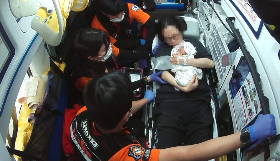 김해동부소방서 삼정119안전센터 구급대원이 산모와 아이 건강상태를 확인하며 병원으로 이송하고 있다. 김해동부소방서 제공