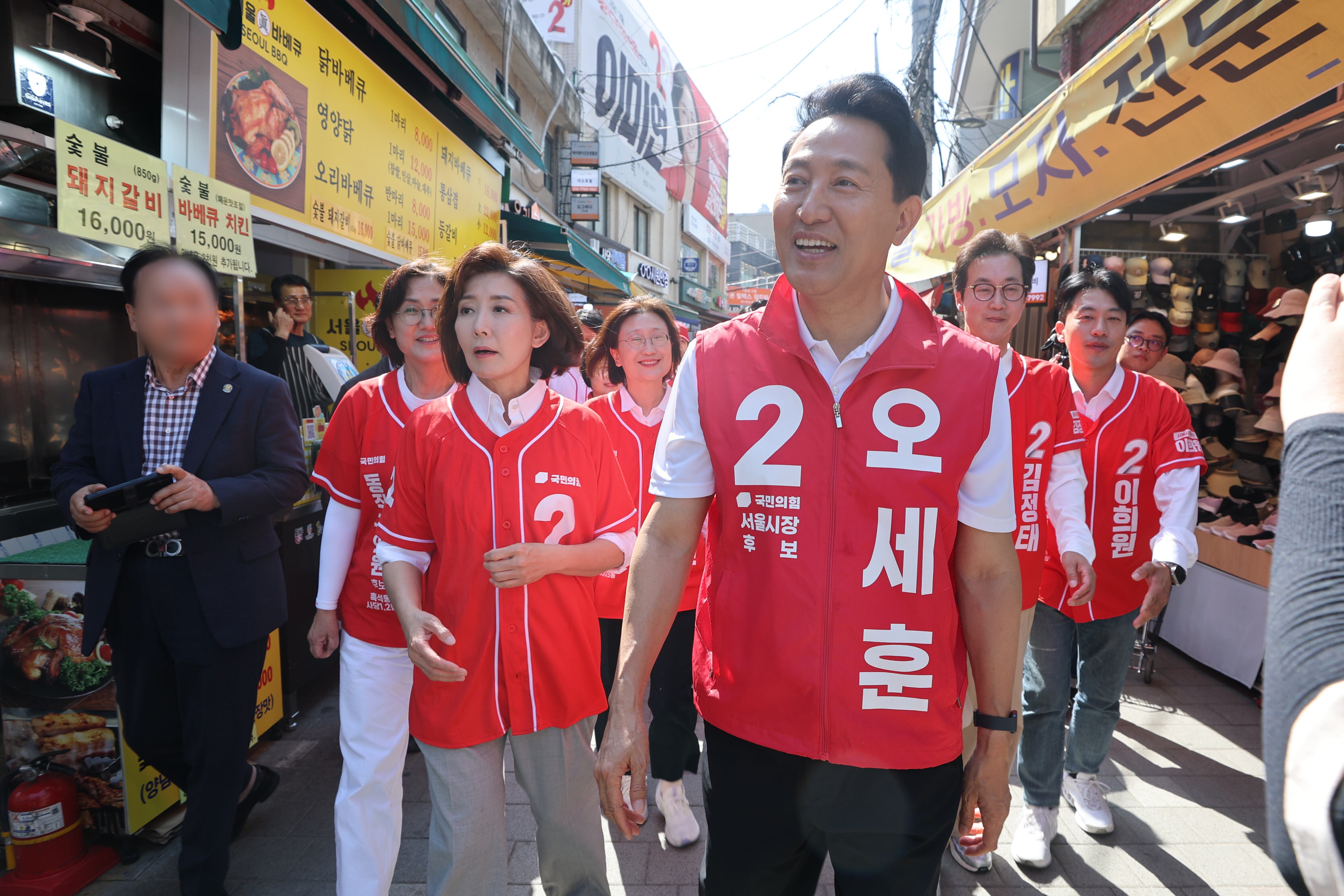 국민의힘 오세훈 서울시장 후보가 22일 서울 동작구 남성사계시장에서 나경원 의원과 함께 상인 및 시민들에게 인사를 하고 있다./연합뉴스
