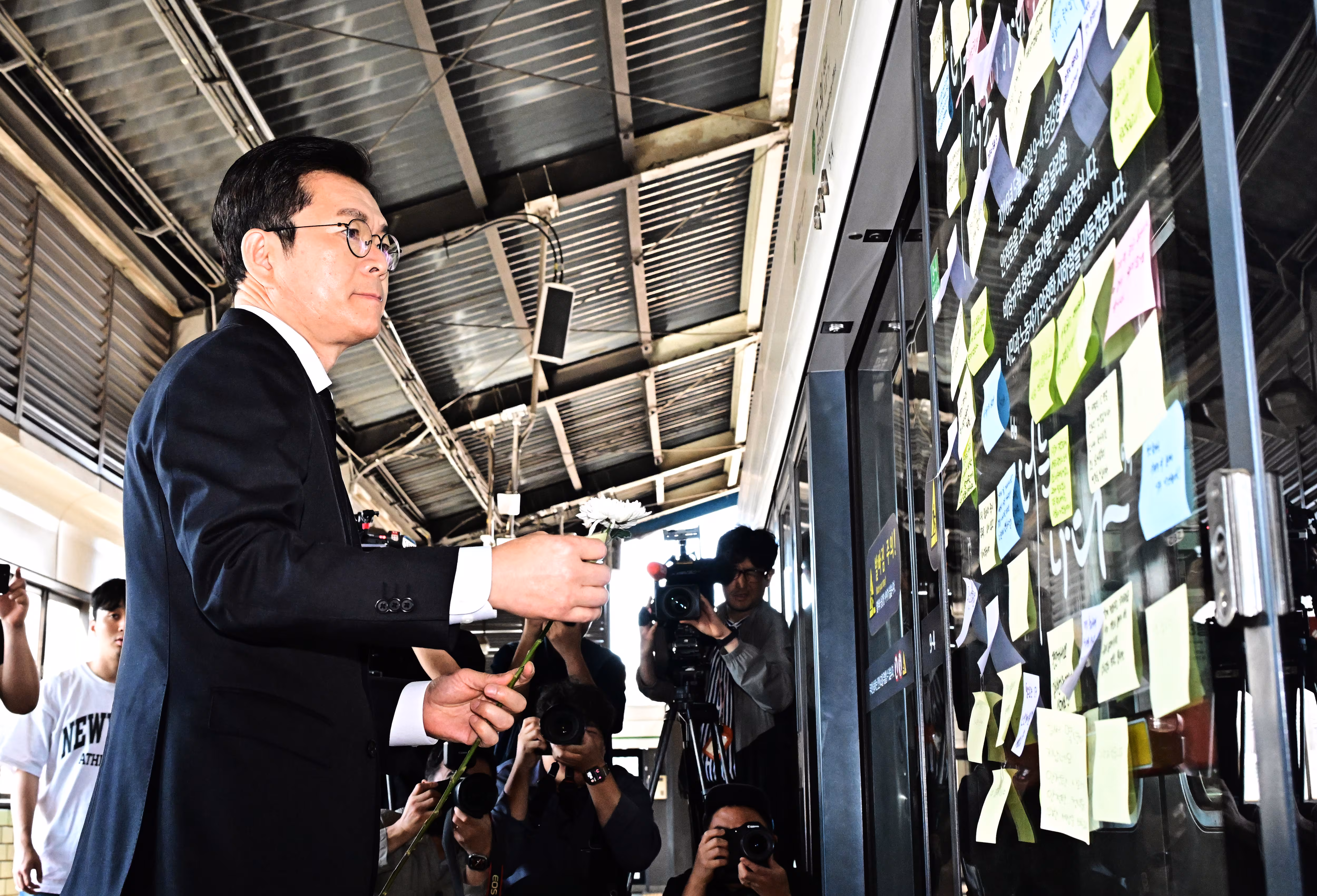정원오 더불어민주당 서울시장 후보가 22일 오전 서울 광진구 구의역 9-4 승강장에서 구의역 참사 10주기 추모 헌화 전 메시지를 부착하고 있다./뉴스1