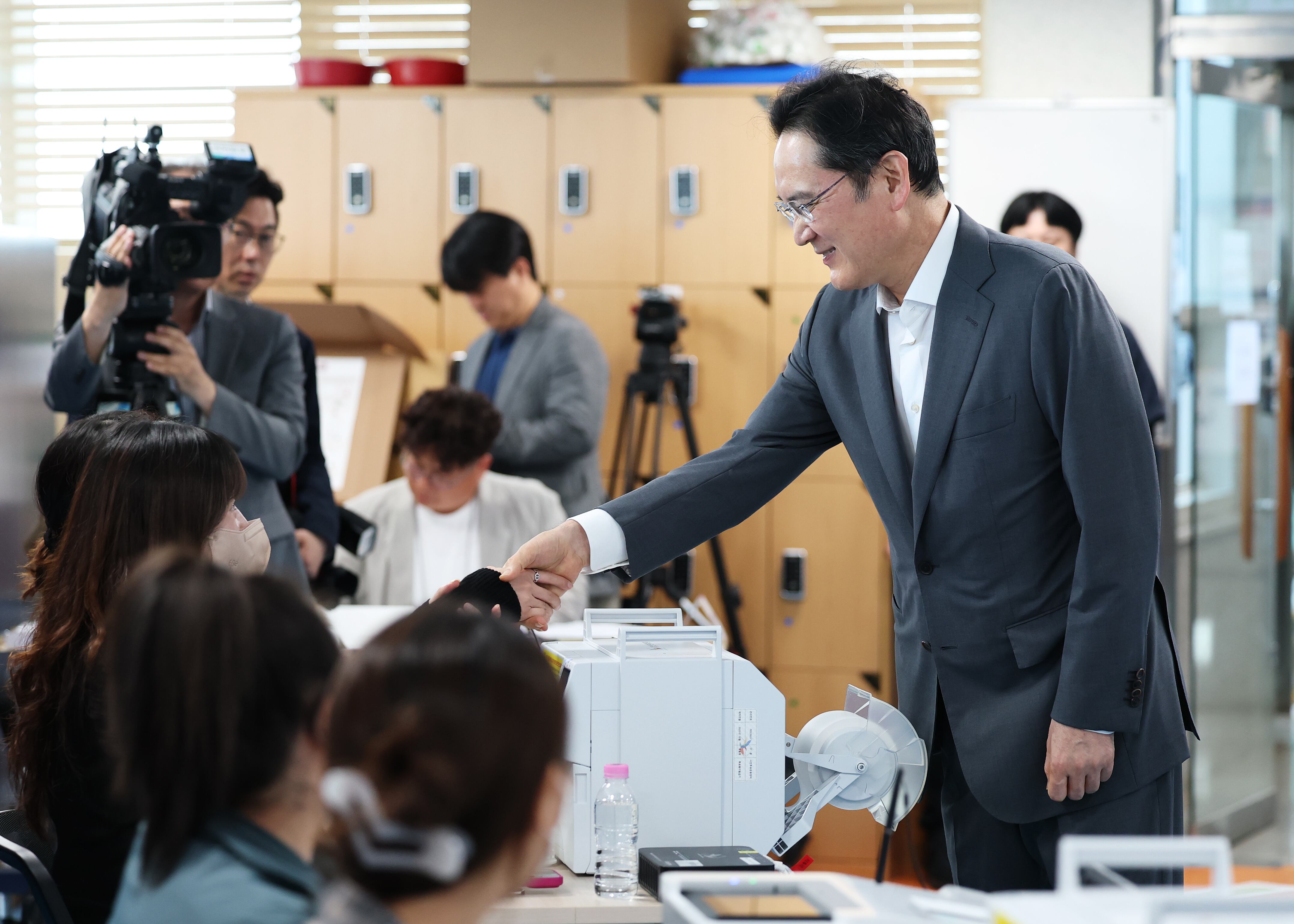 이재용 삼성전자 회장이 제9회 전국동시지방선거 사전투표 첫날인 29일 오전 서울 용산구 한남동주민센터에 마련된 사전투표소를 찾아 투표 사무원들과 악수를 나누고 있다./뉴스1 
