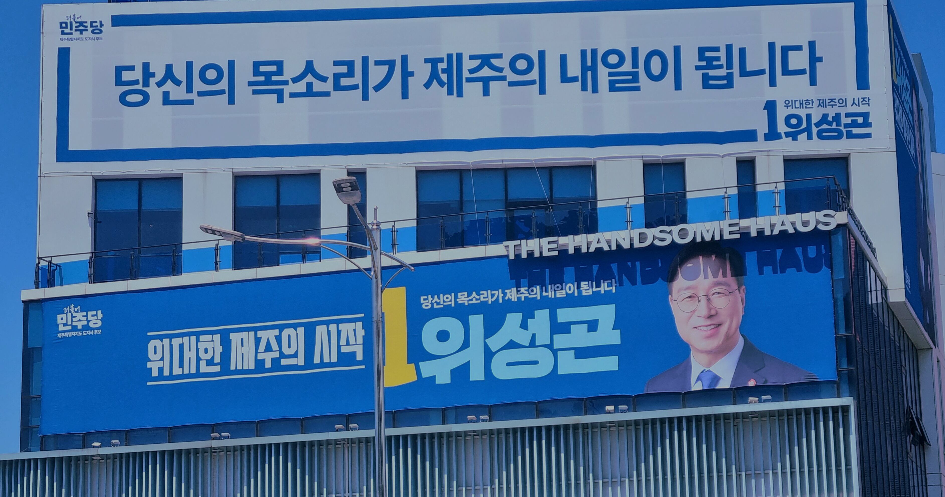위성곤 더불어민주당 제주지사 후보 선거사무소 빌딩 전경. 위 후보 현수막 위에 ‘HANDSOME’이라는 단어가 겹쳐 보인다. /제주=김양혁 기자