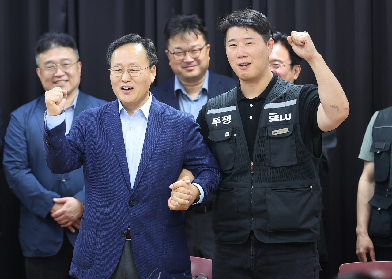 20일 경기도 수원시 장안구 경기고용노동청에서 열린 삼성전자 임금협상을 마친 후 여명구 삼성전자 DS(디바이스솔루션·반도체 사업 담당) 피플팀장과 최승호 삼성그룹 초기업노동조합 삼성전자지부 위원장이 잠정 합의한에 서명한 후 파이팅을 외치고 있다. (공동취재) / 뉴스1