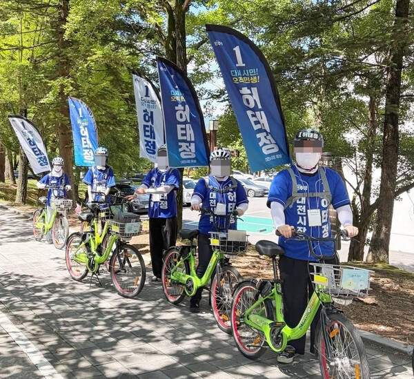 허태정 대전시장 선거캠프 소속 선거운동원들이 대전시 공용자전거 타슈를 이용해 선거운동을 하는 사진이 SNS를 통해 확산되고 있다. /출처 = SNS