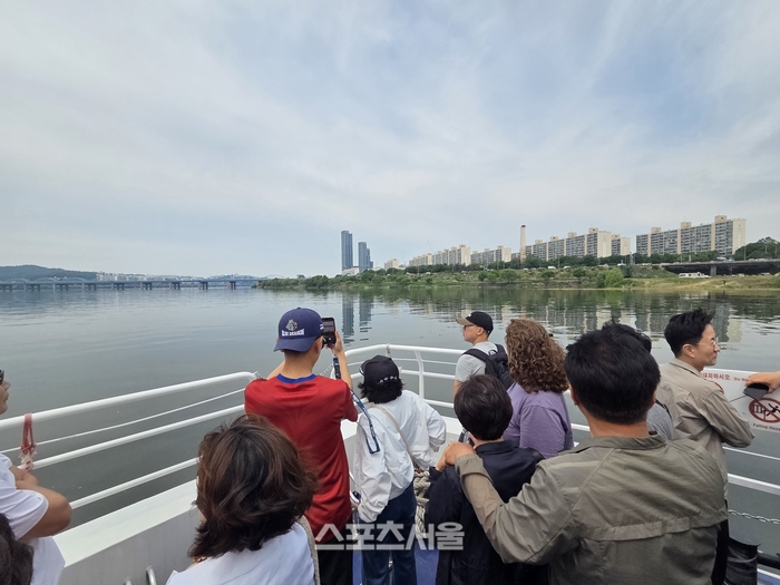 한강버스 야외 데크로 나온 탑승객들이 탁 트인 한강과 서울의 스카이라인을 감상하며 사진을 찍고 있다. 사진 | 원성윤 기자 socool@sportsseoul.com