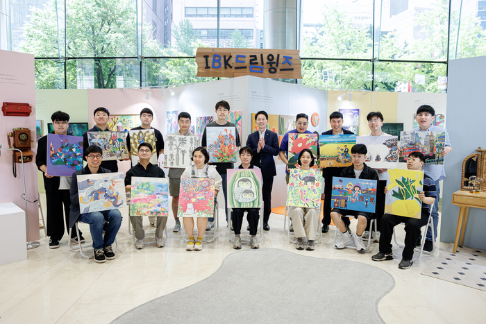 18일 서울 을지로 기업은행 본점에서 (뒷줄 오른쪽에서 여섯번째) 김태형 IBK기업은행 경영전략그룹장과 IBK드림윙즈 작가들이 기념촬영을 하고 있는 모습. 사진 | IBK기업은행