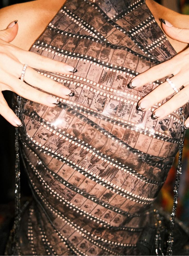 A detailed view of Sabrina Carpenter\'s film strip dress featuring scenes from the 1954 film \'Sabrina\' starring Audrey Hepburn / Credit: Instagram