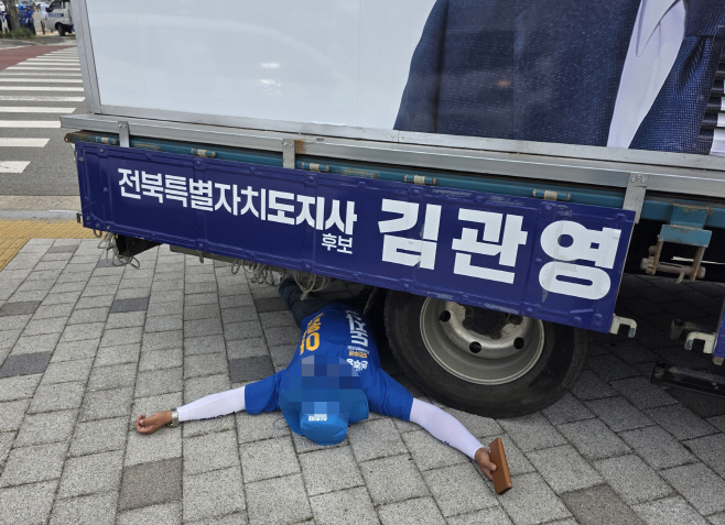 김관영 유세차 아래 드러누운 이원택 선거운동원<YONHAP NO-2904>
