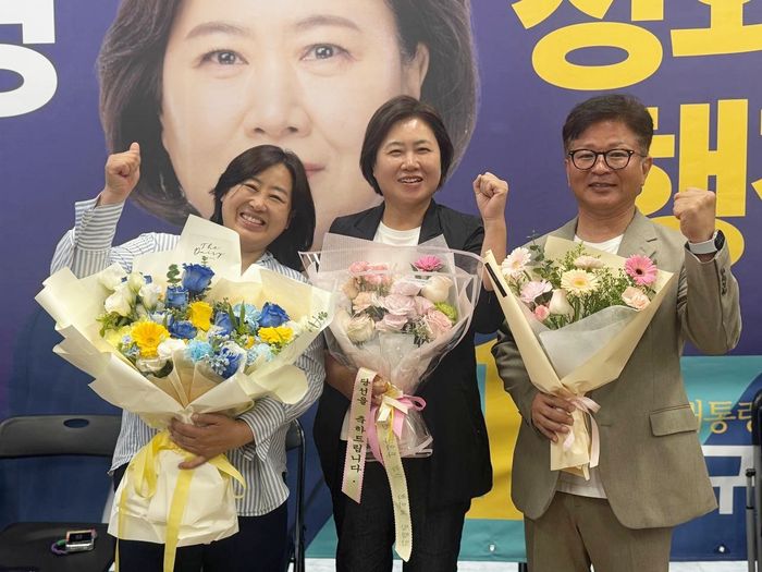 초대 영종구청장으로 당선된 더불어민주당 손화정(가운데) 당선인이 축하 꽃다발을 받고 사진촬영을 하고 있다. ⓒ 손화정 캠프 제공