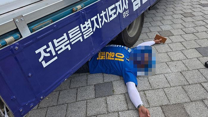 1일 오전 전북 전주시 완산구의 한 네거리에서 더불어민주당 이원택 전북특별자치도지사 후보의 선거운동원이 무소속 김관영 후보 유세차 밑으로 들어가 드러누워 있다. ⓒ연합뉴스