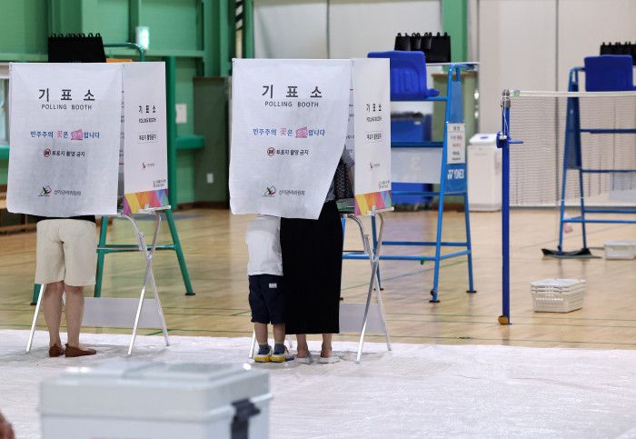 제9회 전국동시지방선거일인 3일 서울 매봉산실내배드민턴장에 마련된 도곡1동 제5투표소에서 아이를 동반한 유권자가 투표를 하고 있다.ⓒ연합뉴스