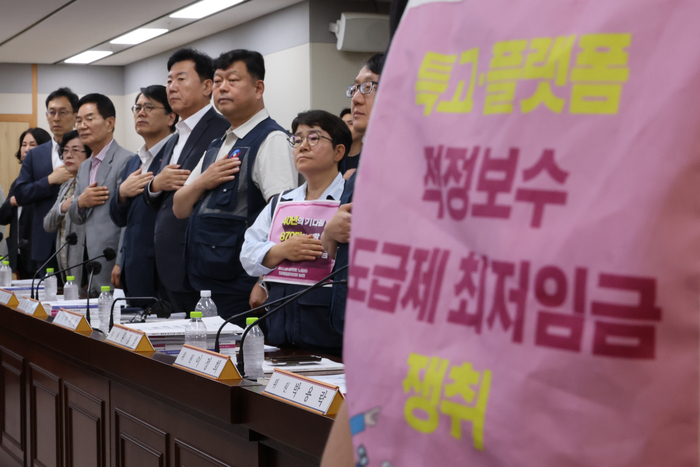 11일 정부세종청사 최저임금위원회에서 열린 제5차 전원회의에서 근로자위원과 사용자위원들이 국기에 경례하고 있다. 연합뉴스.