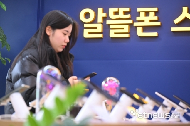알뜰폰 전문 매장에서 한 시민이 알뜰폰을 체험하고 있다.
