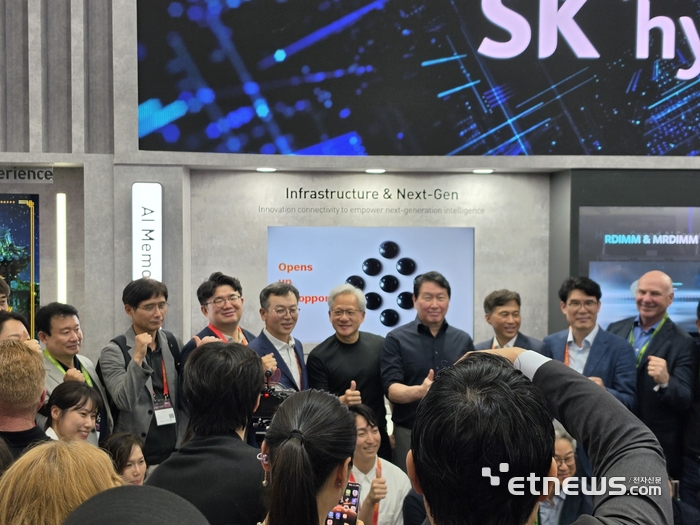 젠슨 황 엔비디아 CEO(사진 가운데)가 SK하이닉스 부스를 방문해 최태원 SK그룹 회장(오른쪽)과 기념 사진을 촬영하고 있다.