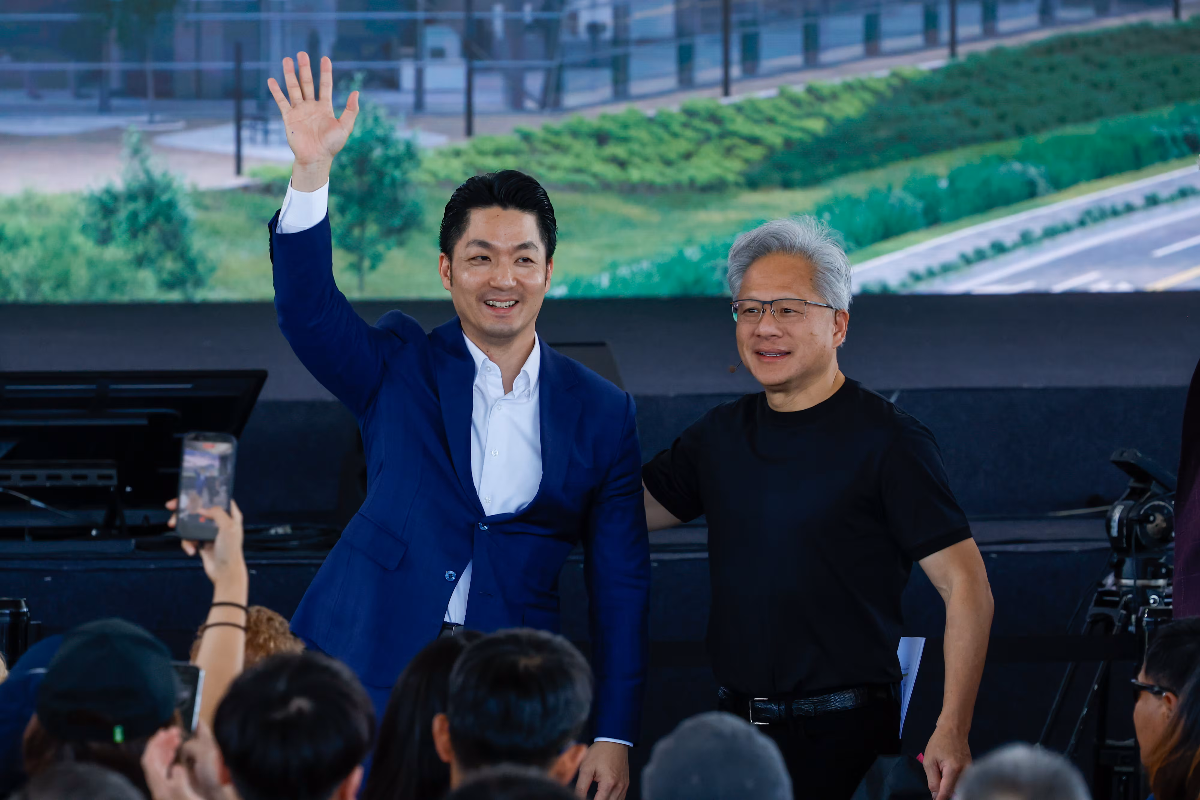 젠슨 황 엔비디아 최고경영자(CEO·오른쪽)와 장완안 타이베이 시장이 지난 27일 대만 타이베이에서 열린 엔비디아 임직원 행사에서 직원들에게 손을 흔들고 있다./EPA연합뉴스