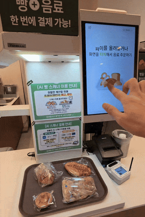AI 계산대 스캐너 위에 빵을 겹치지 않게 올린 후 화면의 '빵 스캔하고 주문하기' 버튼을 눌렀다. AI 계산대가 스캐너 위 빵을 정확히 인식하는 데 8초가 걸렸다. 스캔 후 '담기' 버튼을 누르면 음료 상품 담기 화면 및 결제 화면으로 이동한다.