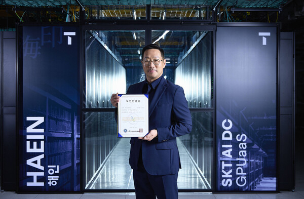 해인 클러스터 앞에서 김명국 SKT AI Factory 사업담당이 CSAP 인증서를 들고 포즈를 취하는 모습. /SKT