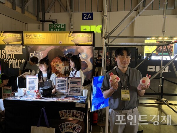 '부산인디커넥트페스티벌(BIC) 2026'의 '숲속의 작은 마녀' 부스 앞에서 박은현 써니사이드업 대표가 사진촬영을 하고 있다. ⓒ포인트경제
