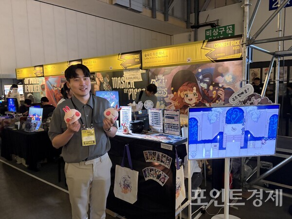 '부산인디커넥트페스티벌(BIC) 2026'의 '숲속의 작은 마녀' 부스 앞에서 박은현 써니사이드업 대표가 사진촬영을 하고 있다. ⓒ포인트경제