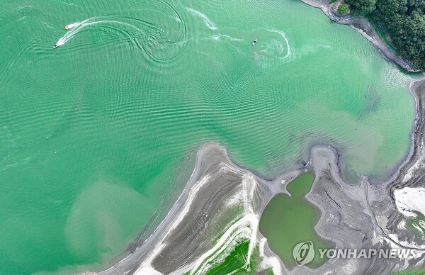 폭염·녹조·가뭄 (칠곡=연합뉴스) 윤관식 기자 = 경북 칠곡군에 폭염중대경보가 발효된 7일 지천면 창평리 한 저수지가 가뭄으로 바닥을 드러내고 수면에는 녹조가 발생해 있는 가운데 피서객들이 수상레저를 즐기며 더위를 식히고 있다. 2026.8.7 psik@yna.co.kr