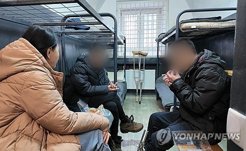 우크라이나군에 생포된 북한군 포로 백모씨와 리모씨가 28일(현지시간) 우크라이나 내 포로수용소에서 김영미PD와 접견하며 탈북민단체들이 보낸 북한음식 '두부밥'을 먹고 있는 모습 / 연합뉴스(겨레얼통일연대 제공)