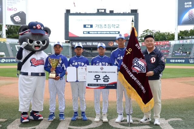 두산 베어스는 18일 키움 히어로즈와 홈 경기에 앞서 '2026 두산베어스기 어린이야구대회' 시상식을 진행했다. 초등부 우승을 차지한 가동초등학교 선수단 대표와 김태룡 두산 구단 단장이 함께 기념촬영하고 있다./두산 베어스 제공