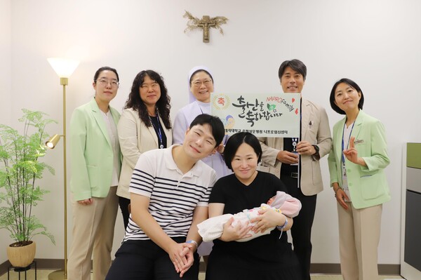 김혜원·김기민 부부가 아들을 안고 출산을 축하하기 위해 방문한 나프로임신센터 의료진과 함께 웃고 있다. / 은평성모병원